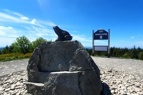 Żaba na skale podziwia skrzyczne widoki. Tablica informuje o wysokości 1257 m n.p.m.
